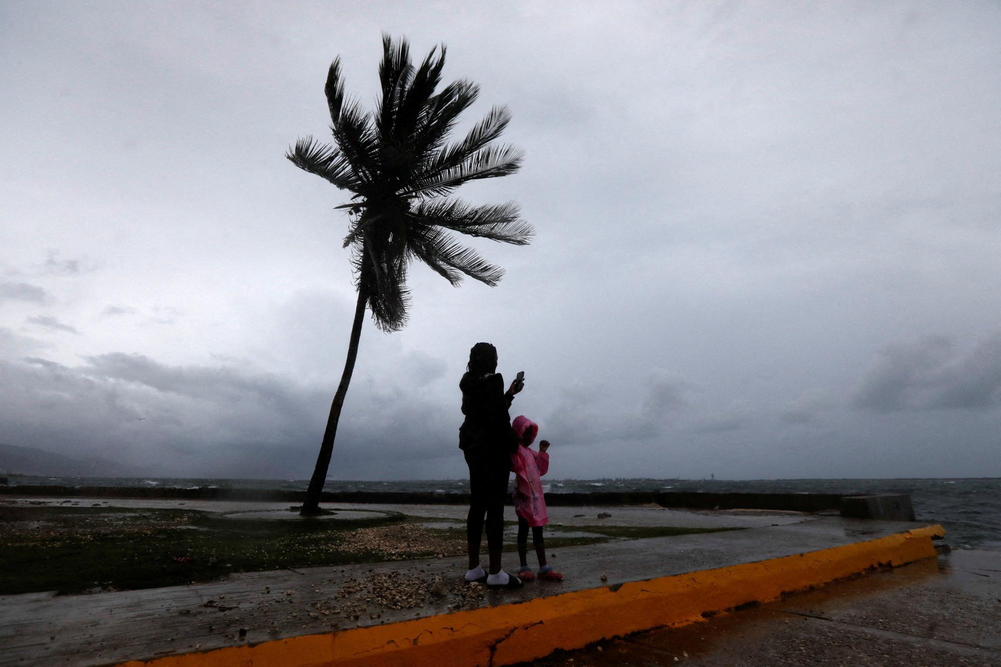 A woman and a child stand along the Kingston waterfront as Hurricane Melissa approaches, in Kingston, Jamaica.  REUTERS/Octavio Jones