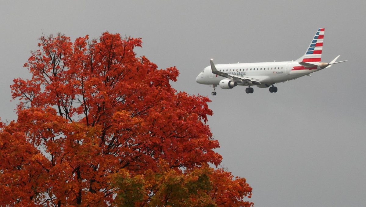 An airliner, making it's approach, flies past a tree in full autumn color, as flight delays surge from the government shutdown which entered its 30th day, in Washington, D.C., U.S., October 30, 2025. REUTERS/Kevin Lamarque